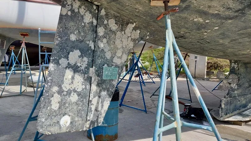 Forever Young Yacht Photos Pics Amel Super Maramu 2000 sailboat under maintenance, supported by blue stands.