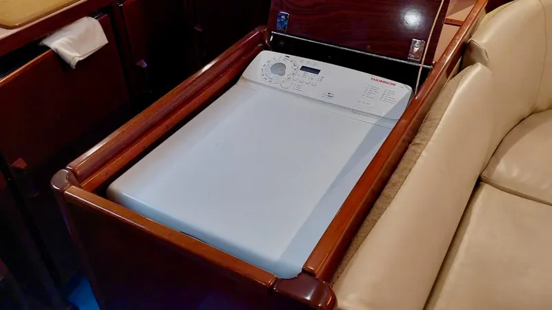 Forever Young Yacht Photos Pics Washing machine in Amel Super Maramu 2000 yacht interior, wooden cabinetry.