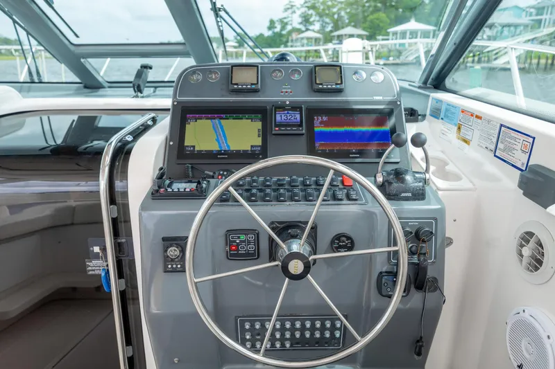 Knot On Call Yacht Photos Pics Helm of 2004 Tiara Yachts 3200 Open with navigation equipment and steering wheel.