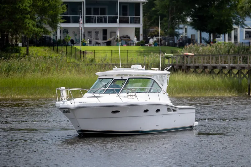 Knot On Call Yacht Photos Pics 2004 Tiara Yachts 3200 Open cruising on a serene lake near waterfront homes.