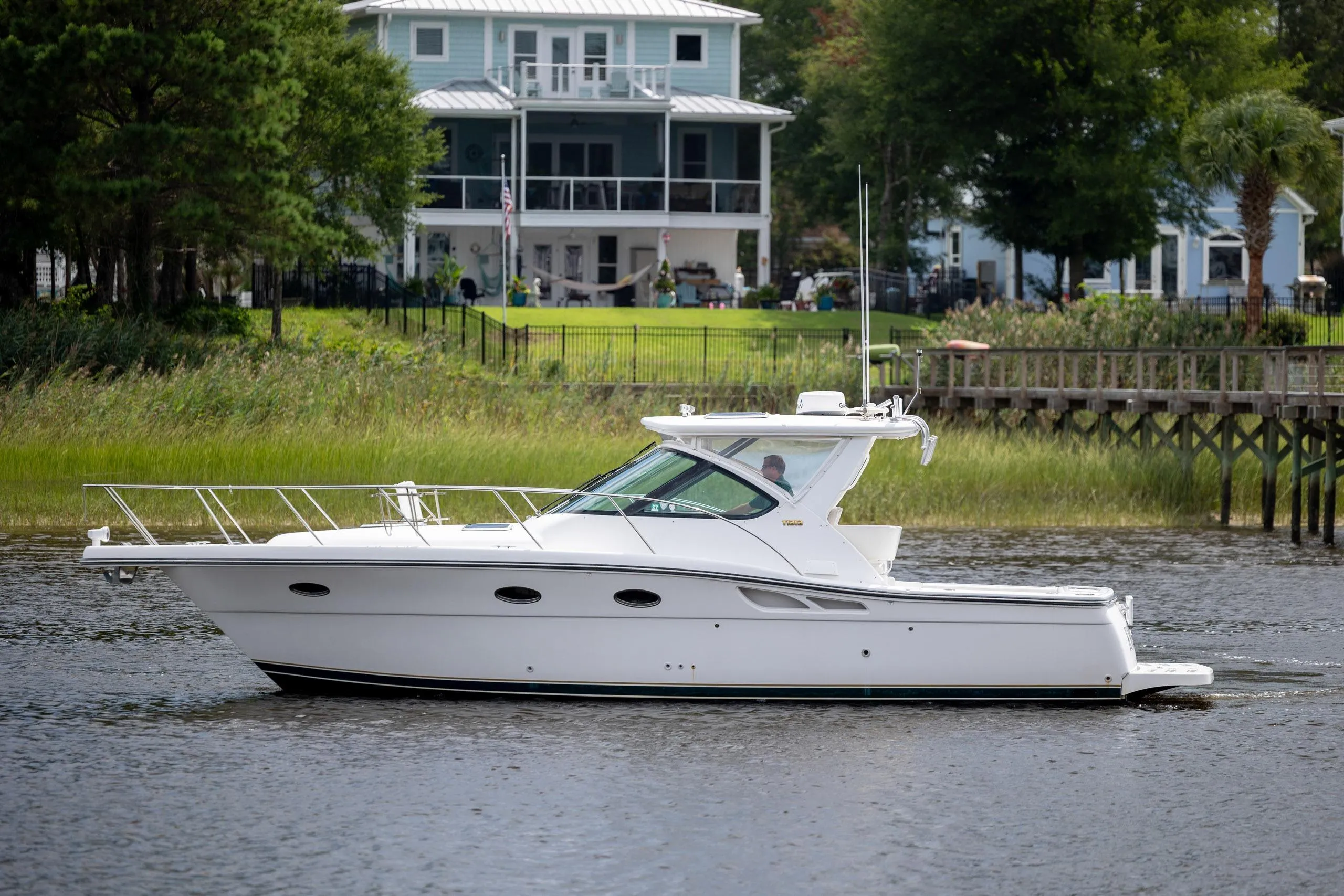 2004 Tiara Yachts 3200 Open cruising on a serene waterway near waterfront homes.