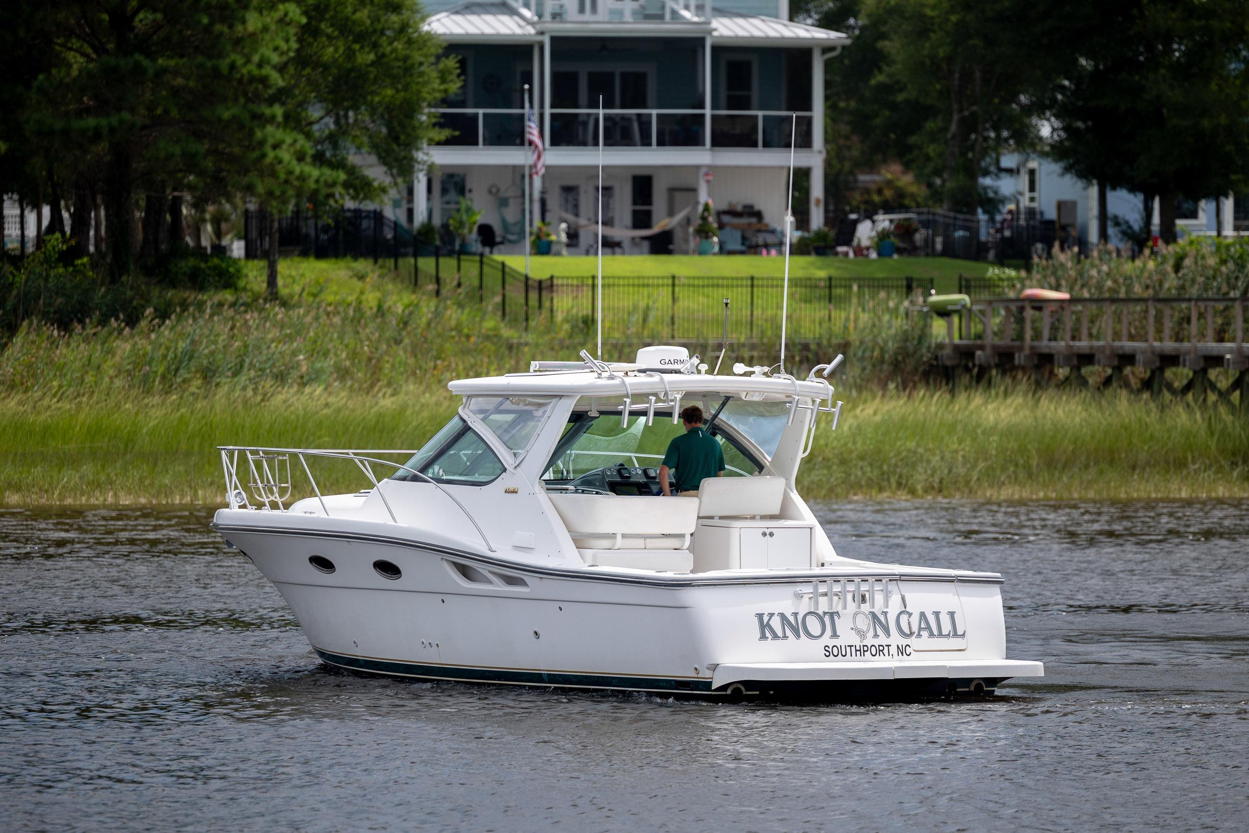 2004 Tiara Yachts 3200 Open boat cruising near a waterfront home.