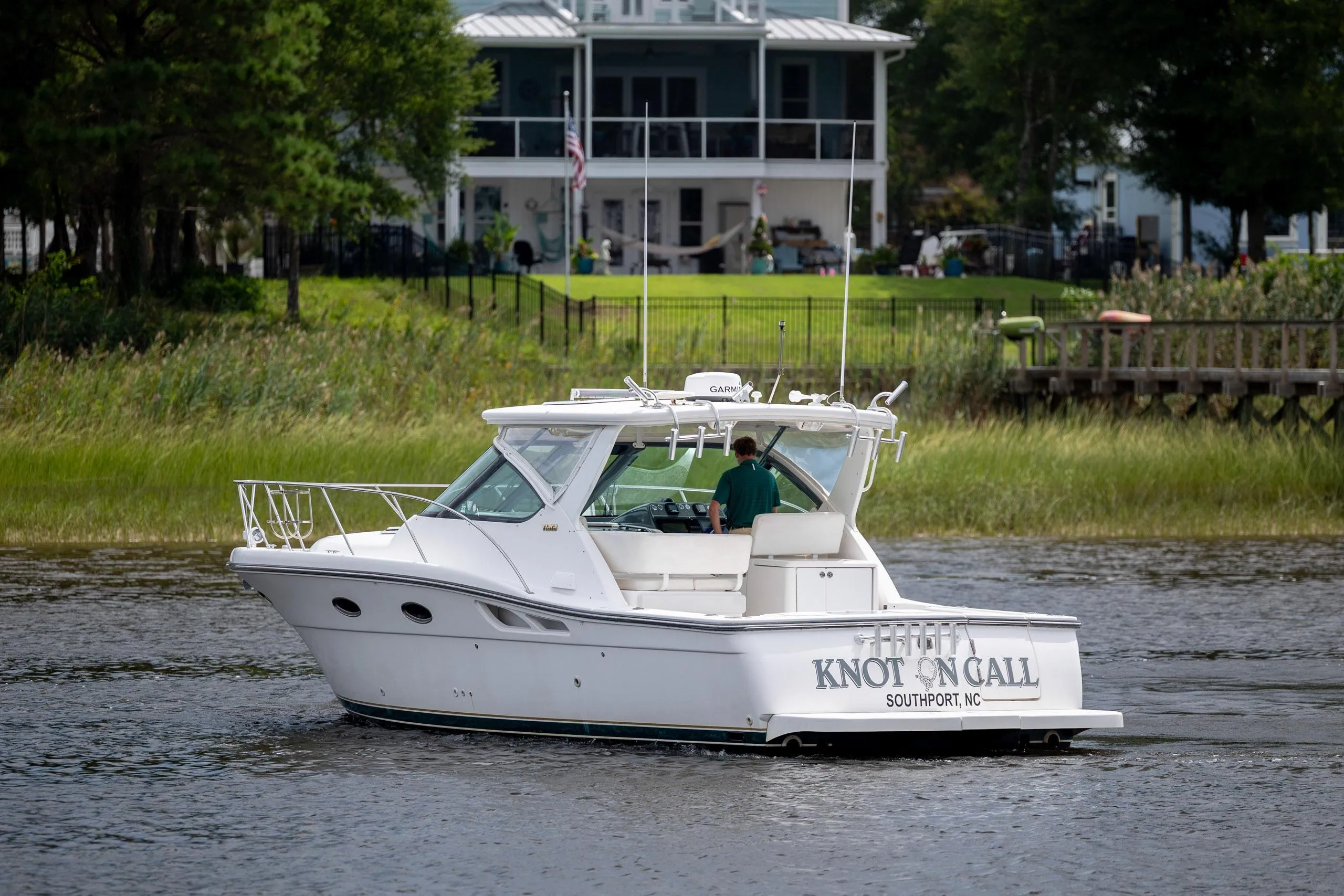 2004 Tiara Yachts 3200 Open boat cruising near a waterfront home.