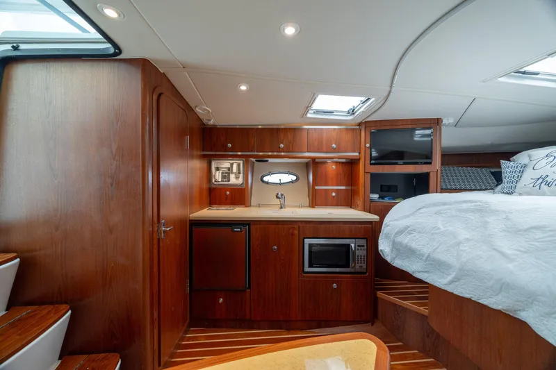 Knot On Call Yacht Photos Pics 2004 Tiara Yachts 3200 Open interior with kitchenette, bed, and wood finish.