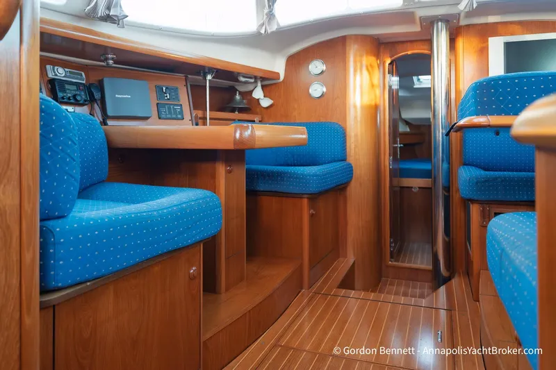 Margaritaville Yacht Photos Pics Interior of 2004 Jeanneau Sun Odyssey 43 DS yacht with blue seating and wooden finishes.