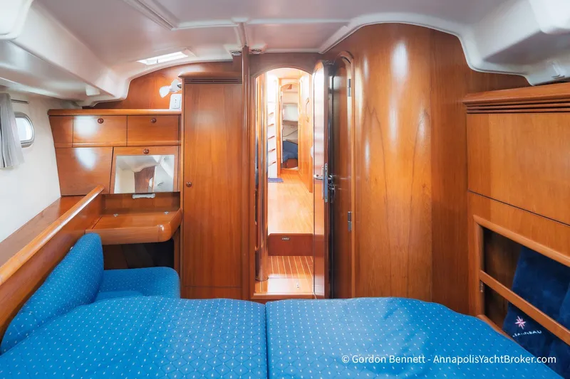 Margaritaville Yacht Photos Pics Interior of 2004 Jeanneau Sun Odyssey 43 DS yacht with wood finish and blue upholstery.