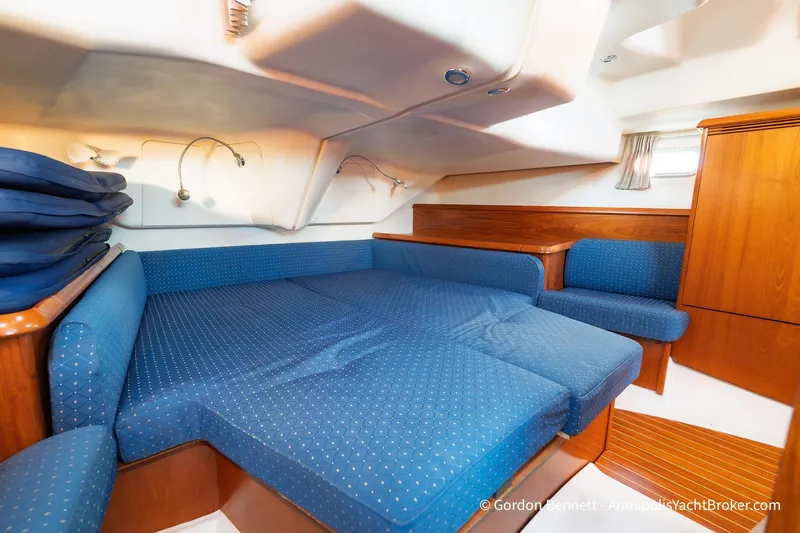 Margaritaville Yacht Photos Pics 2004 Jeanneau Sun Odyssey 43 DS interior cabin with blue upholstery and wooden accents.