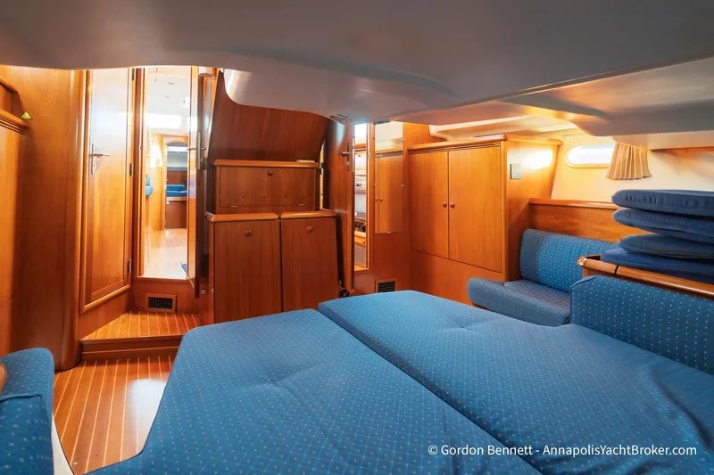 Margaritaville Yacht Photos Pics Luxurious interior of 2004 Jeanneau Sun Odyssey 43 DS yacht with wooden cabinetry and blue upholstery.