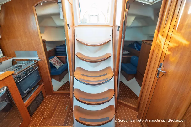 Margaritaville Yacht Photos Pics Interior of 2004 Jeanneau Sun Odyssey 43 DS sailboat with wooden stairs and cozy cabin.