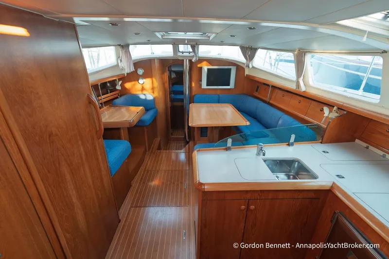 Margaritaville Yacht Photos Pics Interior of 2004 Jeanneau Sun Odyssey 43 DS yacht with wood finish and blue seating.