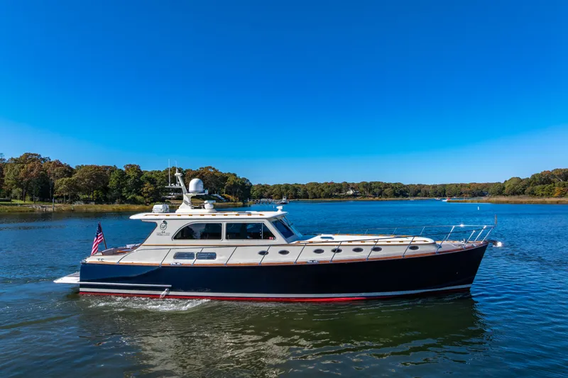 Holly Ann Yacht Photos Pics 2010 Vicem 64 Classic yacht cruising on a serene lake under a clear blue sky.