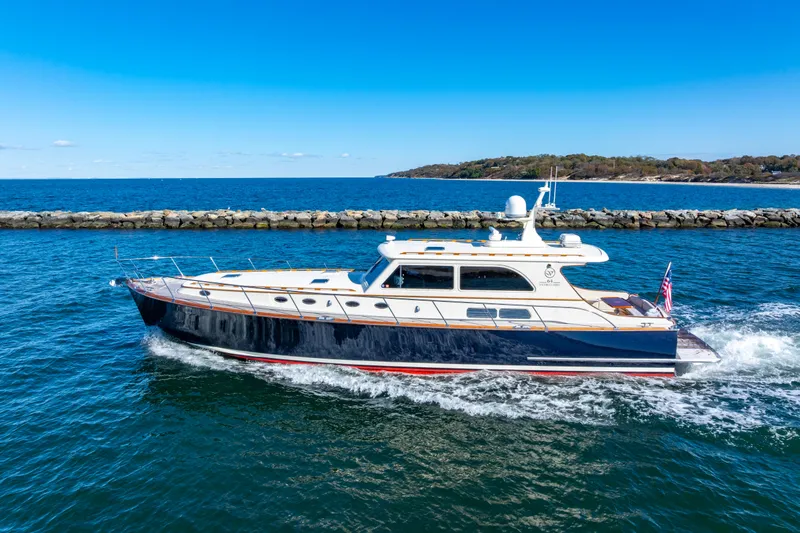 Holly Ann Yacht Photos Pics 2010 Vicem 64 Classic yacht cruising on blue ocean near rocky shoreline.