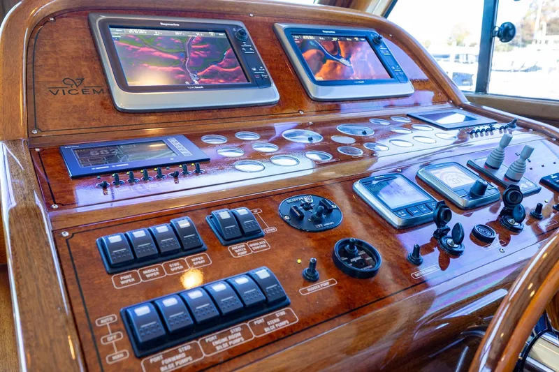 Holly Ann Yacht Photos Pics Control panel of a 2010 Vicem 64 Classic yacht with navigation screens and controls.