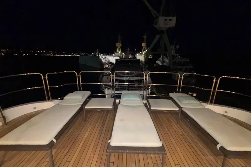  Yacht Photos Pics Deck of 2015 Benetti 121 yacht with lounge chairs at night.