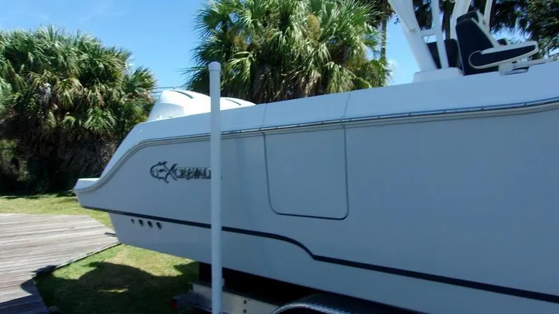  Yacht Photos Pics 2022 Crevalle 33 CSF Offshore Fishing boat on trailer, surrounded by palm trees.