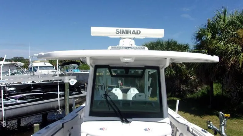  Yacht Photos Pics 2022 Crevalle 33 CSF Offshore Fishing boat with Simrad radar, docked near palm trees.