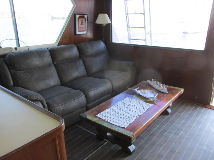 My Way IV Yacht Photos Pics 1987 Hatteras Convertible yacht interior with leather sofa and wooden coffee table.