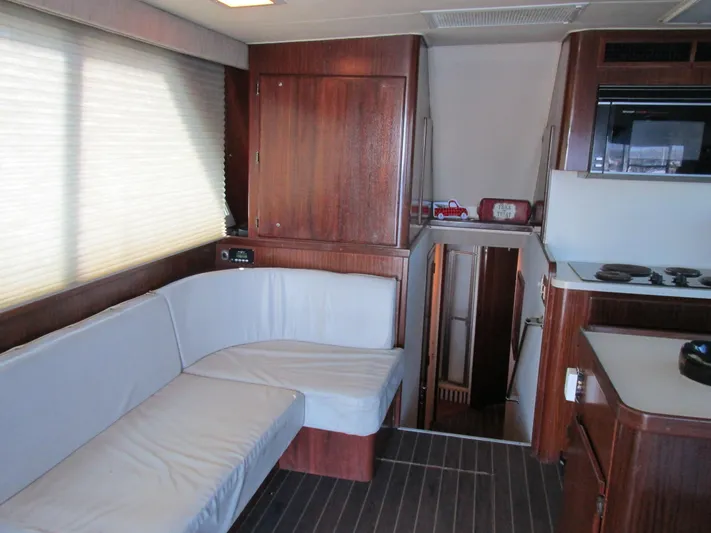 My Way IV Yacht Photos Pics Interior of 1987 Hatteras Convertible yacht with wood paneling and white seating.