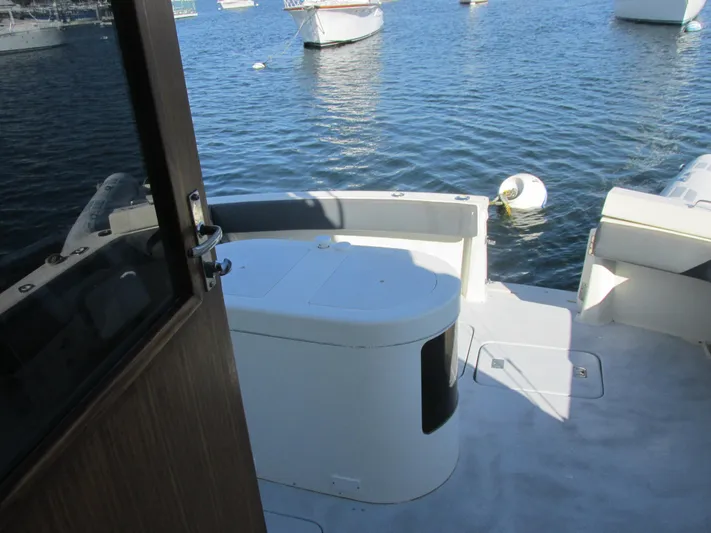 My Way IV Yacht Photos Pics 1987 Hatteras Convertible yacht deck with seating, overlooking calm water and moored boats.
