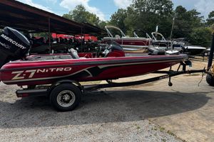 Red 2011 Nitro Z7 boat on trailer, parked outdoors with other boats in background.