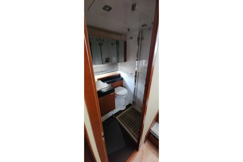  Yacht Photos Pics Bathroom interior of 2016 Jeanneau Prestige 50 yacht, featuring modern fixtures and wooden cabinetry.