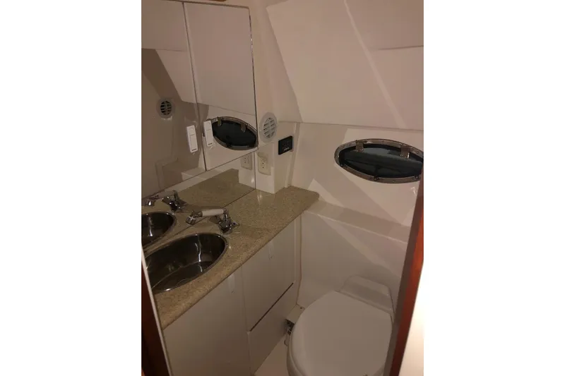  Yacht Photos Pics Bathroom interior of 2006 Fountain 38 Express Cruiser with sink and porthole window.