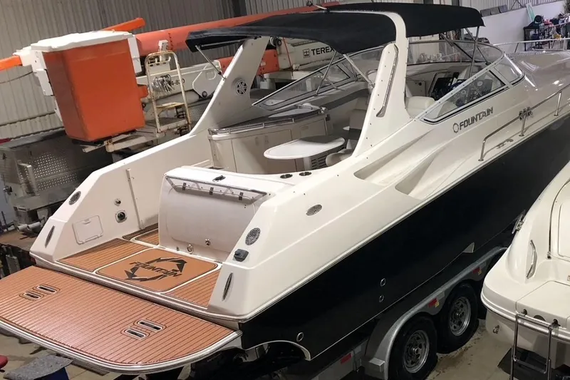  Yacht Photos Pics 2006 Fountain 38 Express Cruiser in a storage facility, showcasing sleek design and spacious deck.