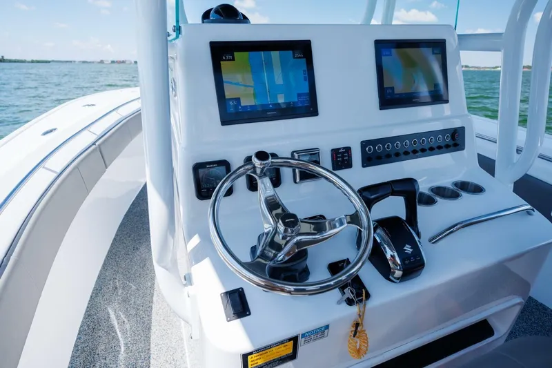  Yacht Photos Pics 2022 Cape Horn 31 T boat dashboard with dual screens and steering wheel on open water.