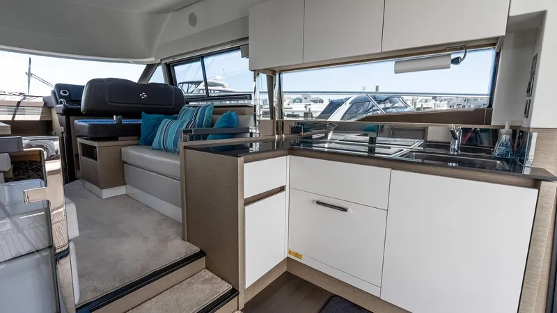  Yacht Photos Pics Luxurious interior of 2022 Prestige 460 Fly yacht with modern kitchen and seating area.