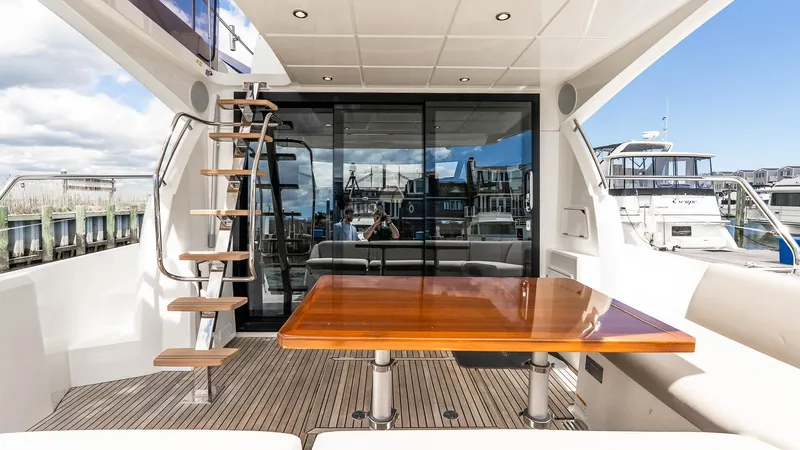 Yacht Photos Pics Prestige 460 Fly 2022 yacht interior with wooden table and staircase, docked at marina.