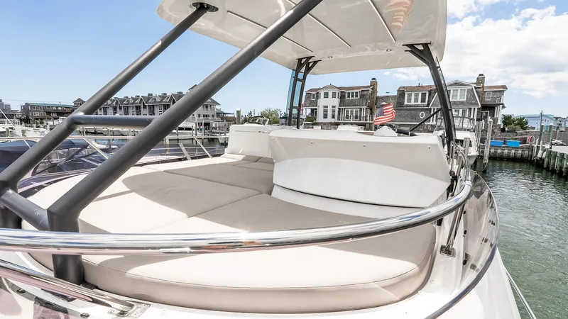  Yacht Photos Pics 2022 Prestige 460 Fly yacht with spacious deck, docked near waterfront homes.
