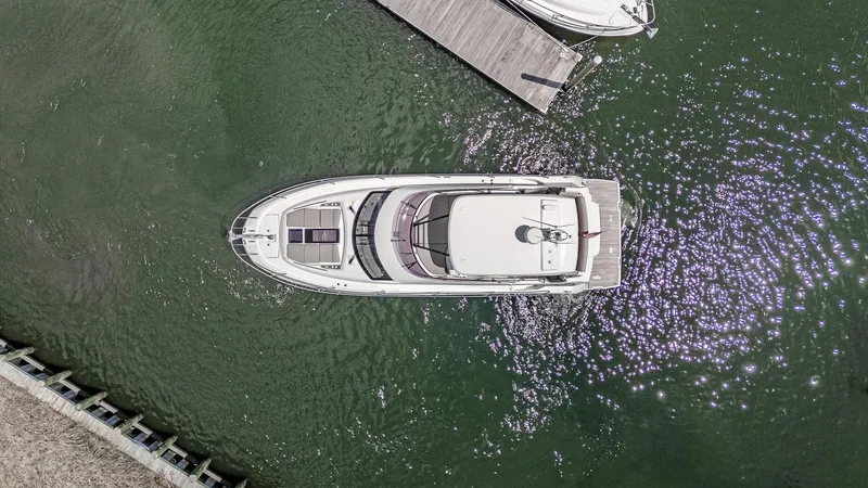  Yacht Photos Pics Aerial view of 2022 Prestige 460 Fly yacht docked in calm waters.