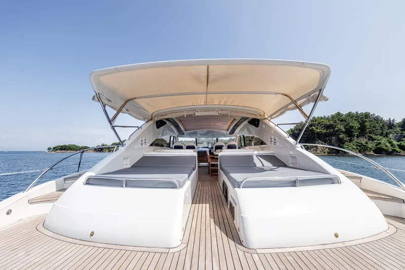 Princess V65 Yacht Photos Pics Luxurious 2003 Princess V65 yacht with spacious deck and canopy, cruising on serene waters.