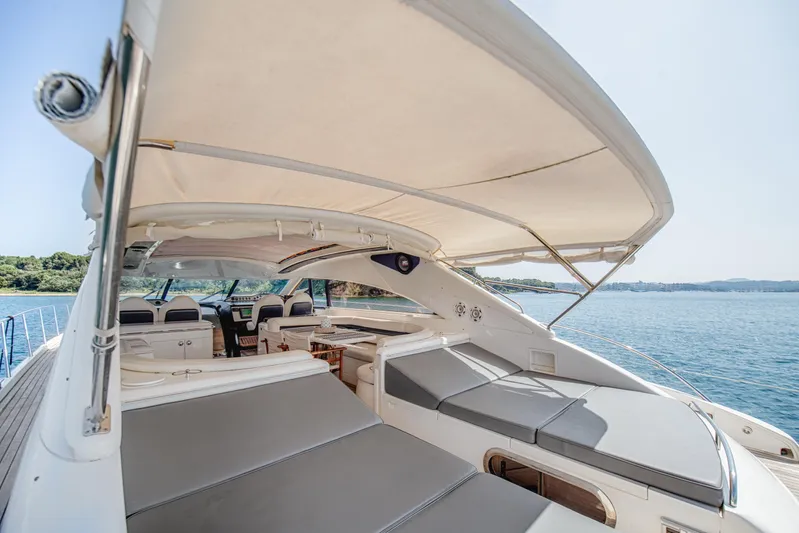 Princess V65 Yacht Photos Pics Luxurious 2003 Princess V65 yacht with spacious deck and seating, cruising on serene waters.