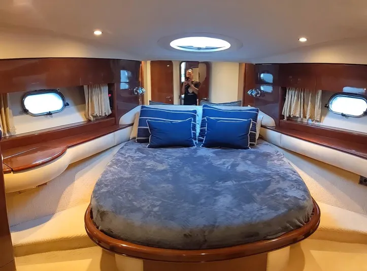 Princess V65 Yacht Photos Pics Luxurious cabin interior of 2003 Princess V65 yacht with plush bedding and elegant wood finishes.
