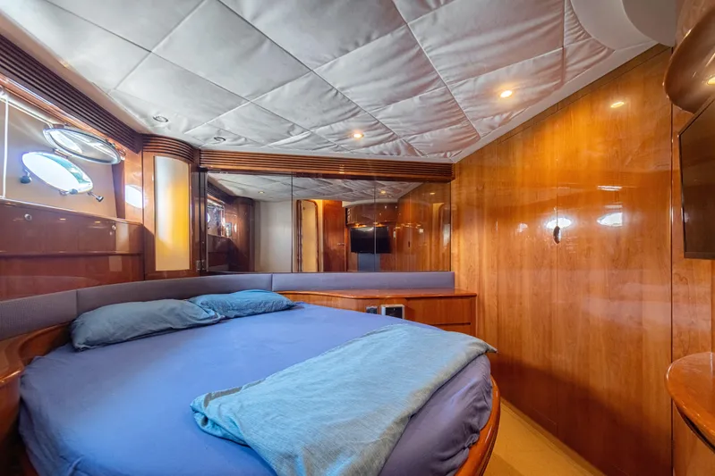 Princess V65 Yacht Photos Pics Luxurious cabin interior of a 2003 Princess V65 yacht with wood paneling and cozy bedding.