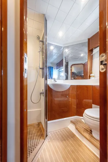 Princess V65 Yacht Photos Pics Luxurious bathroom in 2003 Princess V65 yacht with wood accents and modern fixtures.