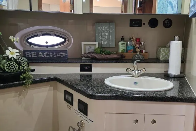  Yacht Photos Pics 2005 Cruisers Yachts 440 Express bathroom with sink, decor, and porthole window.