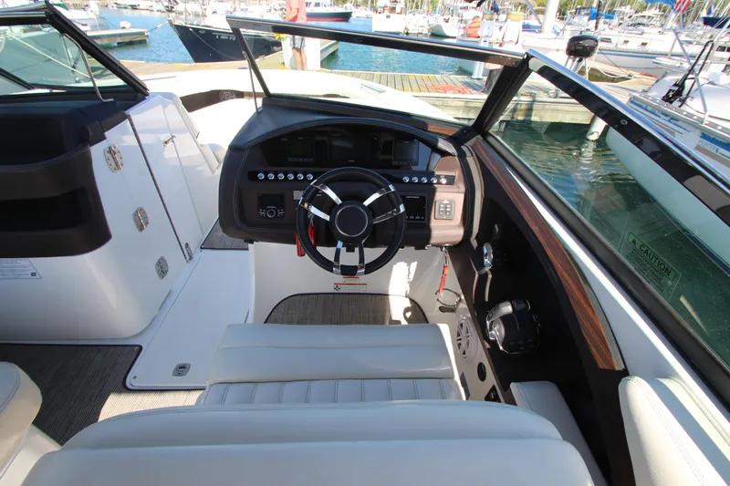  Yacht Photos Pics 2016 Cobalt R30 boat cockpit with steering wheel, dashboard, and marina view.
