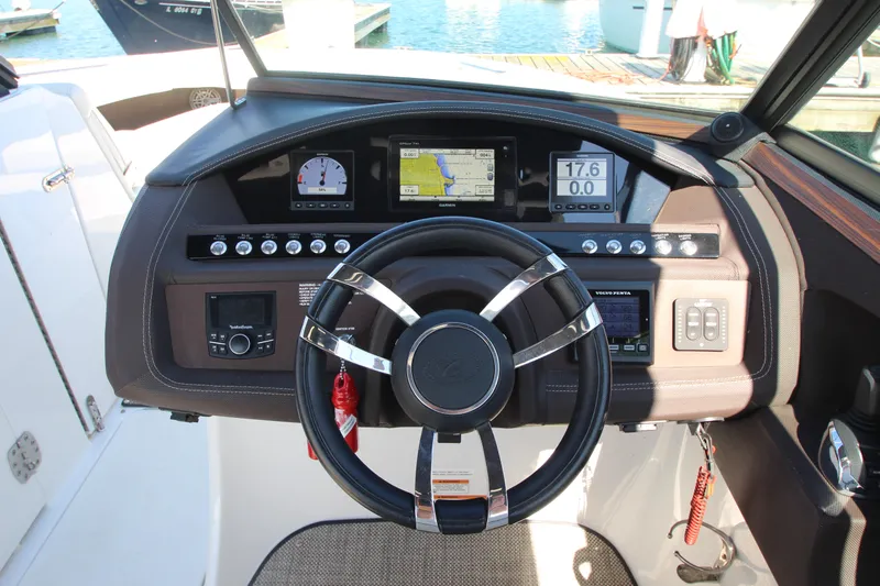  Yacht Photos Pics Steering wheel and dashboard of a 2016 Cobalt R30 boat, featuring navigation and control instruments.