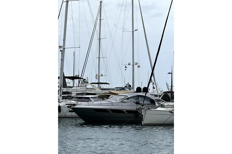  Yacht Photos Pics 2023 Pershing 5x yacht docked among sailboats in a marina.