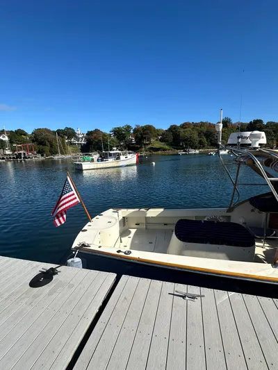 Golden Gate Yacht Photos Pics Hinckley T29 Express 1997 docked by a serene waterfront with American flag.