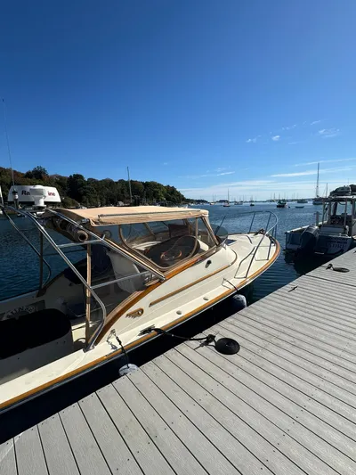 Golden Gate Yacht Photos Pics 1997 Hinckley T29 Express docked by a serene waterfront under a clear blue sky.