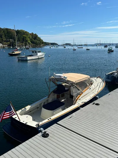 Golden Gate Yacht Photos Pics 1997 Hinckley T29 Express docked in a scenic marina with calm waters and sailboats.