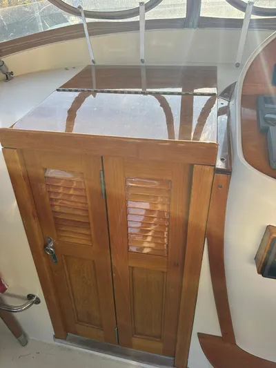 Golden Gate Yacht Photos Pics Wooden cabinet on 1997 Hinckley T29 Express boat with polished finish and louvered doors.