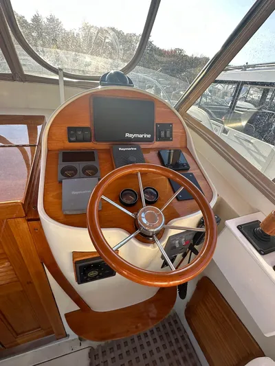 Golden Gate Yacht Photos Pics 1997 Hinckley T29 Express helm with wooden steering wheel and Raymarine navigation system.