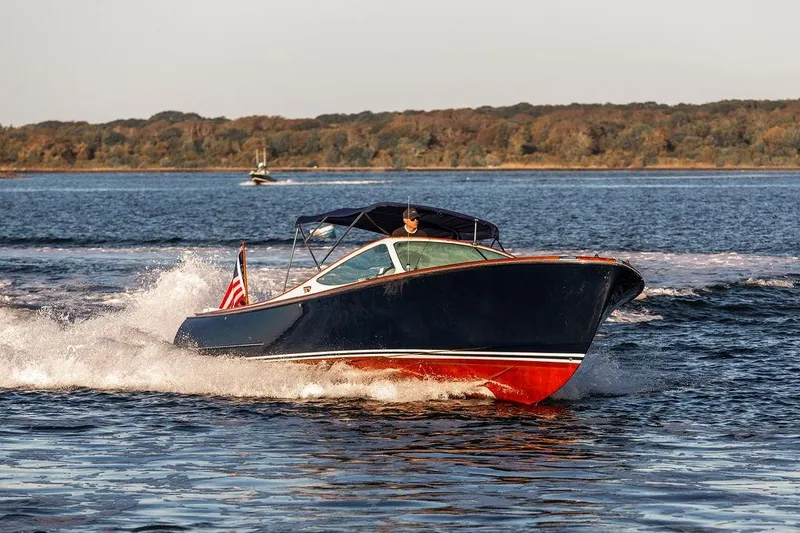 Coot Yacht Photos Pics 2005 Hinckley Talaria 29R cruising on a scenic lake with forested shoreline.