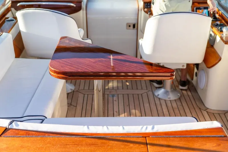 Coot Yacht Photos Pics Interior of 2005 Hinckley Talaria 29R with elegant wood table and white seating.