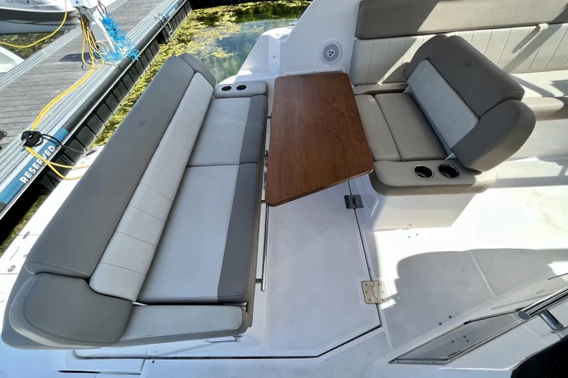  Yacht Photos Pics 2013 Regal 35 Sport Coupe interior with seating and wooden table on a boat dock.