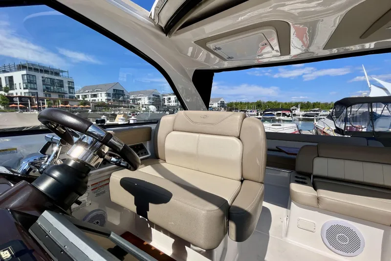  Yacht Photos Pics 2013 Regal 35 Sport Coupe interior with helm, beige seating, and marina view.
